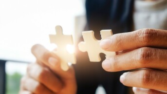 Business woman hands connecting jigsaw puzzle. Business solutions, success and strategy concept. Businessman hand connecting jigsaw puzzle.Close up photo with selective focus.