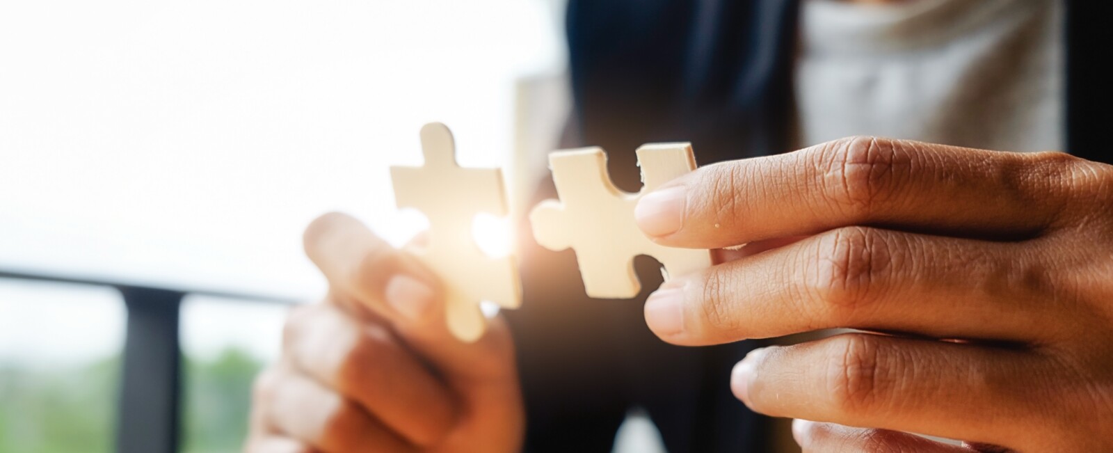 Business woman hands connecting jigsaw puzzle. Business solutions, success and strategy concept. Businessman hand connecting jigsaw puzzle.Close up photo with selective focus.